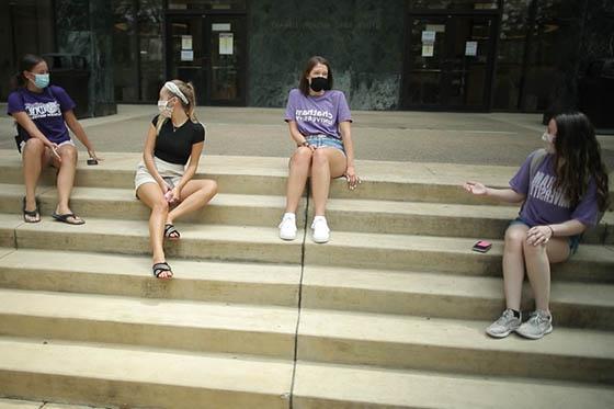 Photo of four Chatham University 学生, masked, seated socially distanced on the library steps
