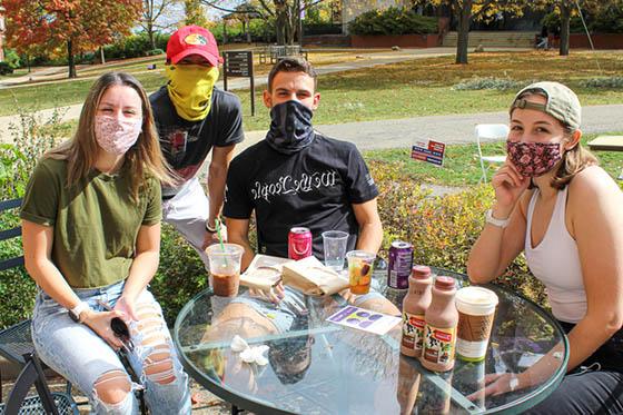 Photo of four Chatham University 学生 in masks, hanging out together outside on 足球波胆平台